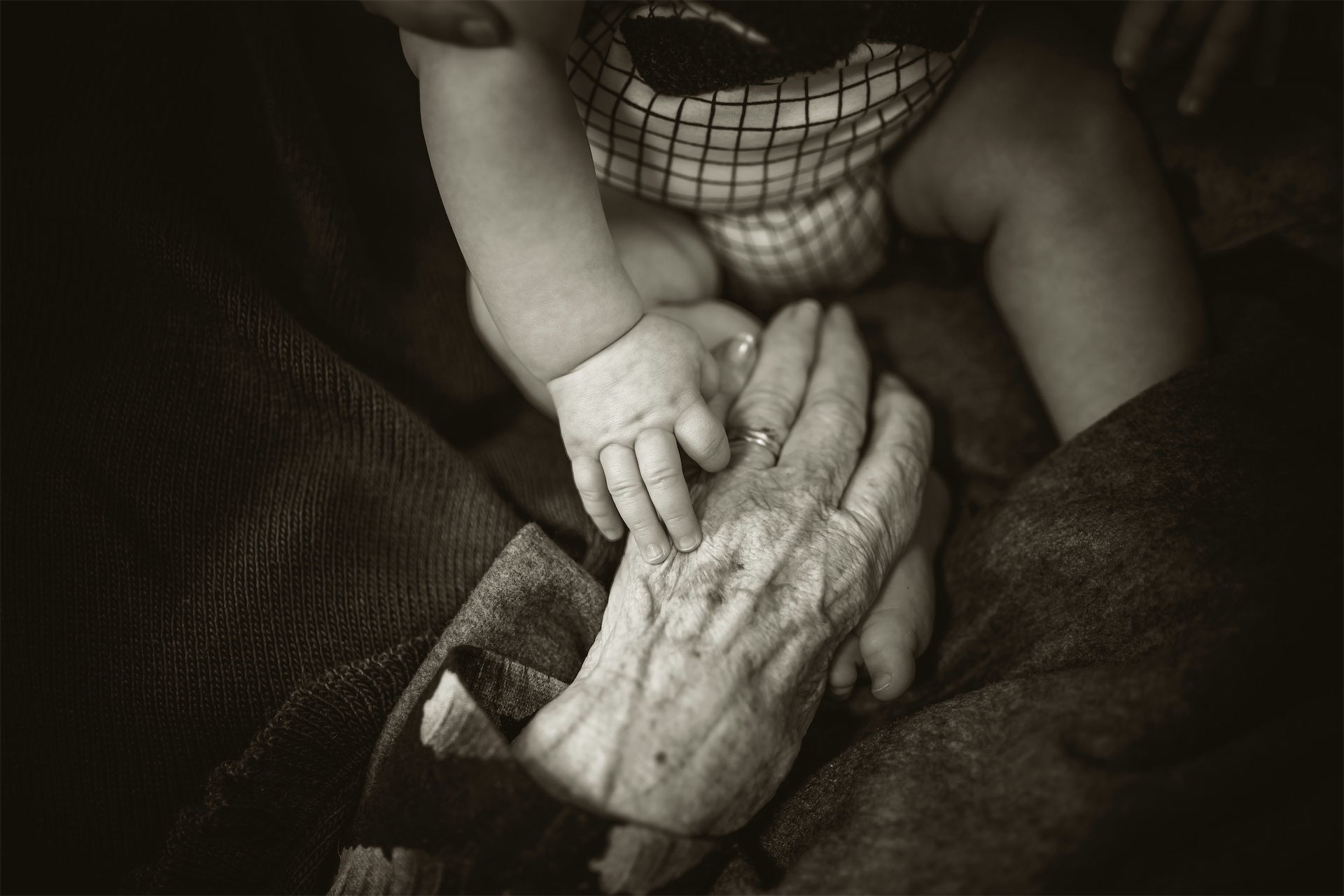 Generationer - barnhand håller äldre persons hand